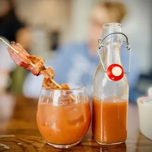 a bottle of bacon and a glass of orange juice