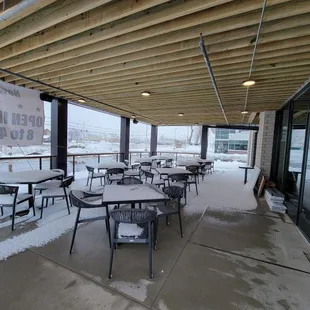 a covered patio with tables and chairs