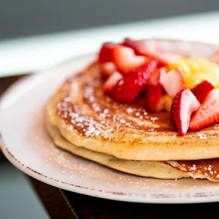 a stack of pancakes with fruit on top