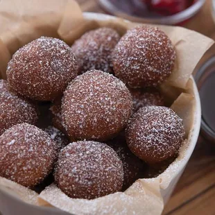 a bowl of sugar coated doughnuts