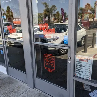 Scratched out door hours and NEW! cheap plastic sign: NOON -