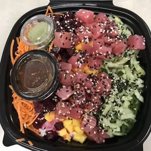 Tuna poke bowl with beets mango seaweed salad cucumber sesame seeds carrots wasabi chili sauce on white rice