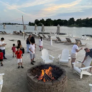 a group of people standing around a fire pit