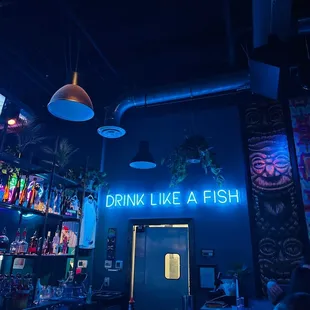 a neon sign that says drink like a fish