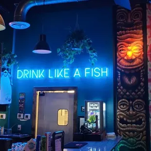 a neon sign that reads drink like a fish