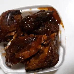 ribs and sauce in a styrofoam container