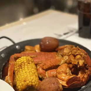 crab legs, corn, potatoes, and corn on the cob
