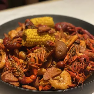 crawfish, corn and potatoes in a skillet
