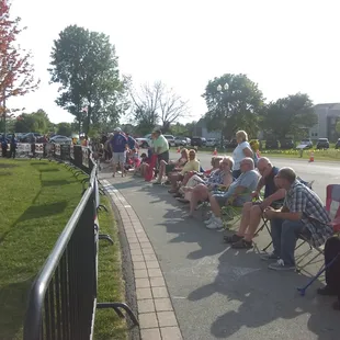 a long line of people sitting on lawn chairs