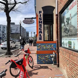 a row of bicycles parked on the sidewalk