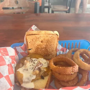 a sandwich and onion rings in a basket