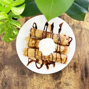 a plate of bananas with ice cream and chocolate sauce