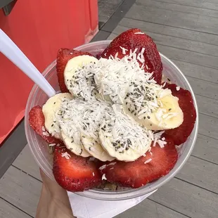 a person holding a bowl of fruit