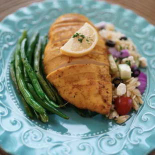 a plate of food with chicken, asparagus, and green beans