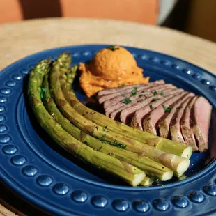 a plate of meat and asparagus