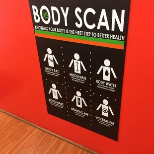 a body scan sign on a red wall