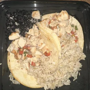 a chicken taco with rice and beans