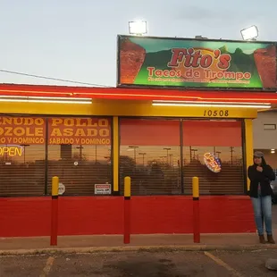 a woman standing in front of the restaurant