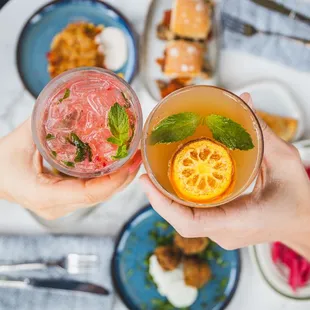 two people toasting with drinks