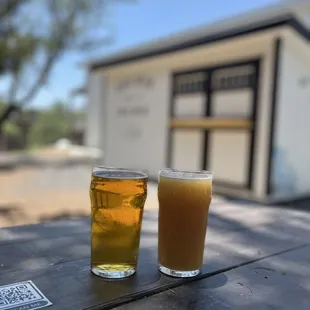 two glasses of beer on a picnic table