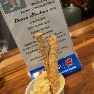 a bowl of ice cream and two sticks