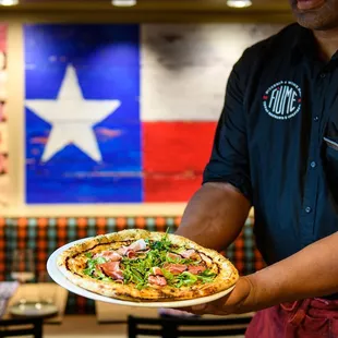 a man holding a pizza