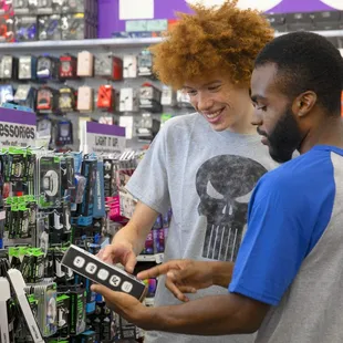 a man and a boy looking at a cell phone in a store