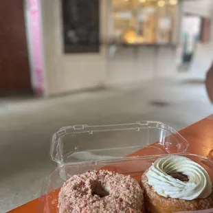 two doughnuts in a plastic container