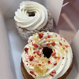 two doughnuts with white frosting and sprinkles