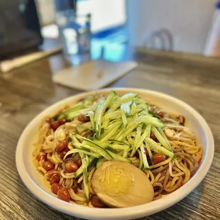 a bowl of noodles with an egg