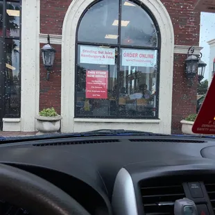 a view of a restaurant through the windshield of a car