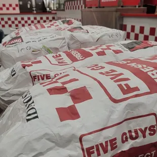 a pile of bags of food in a fast food restaurant
