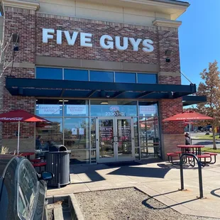 the front entrance of a five guys restaurant