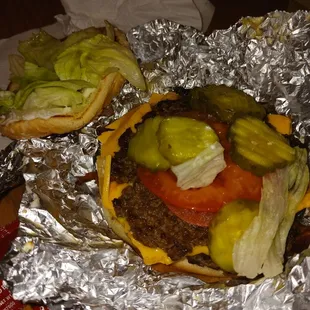 a hamburger and a pickle on tin foil