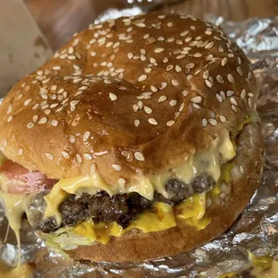 a hamburger covered in cheese and meat