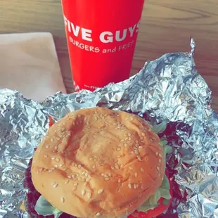 a hamburger and a drink on a table