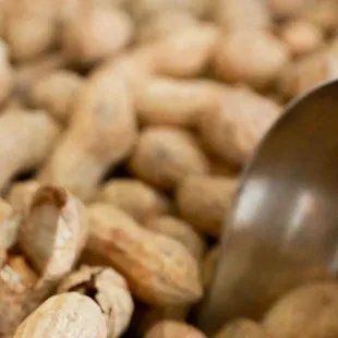 a scooper scooping peanuts into a pile