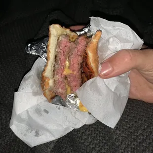 a person holding a sandwich in their hand
