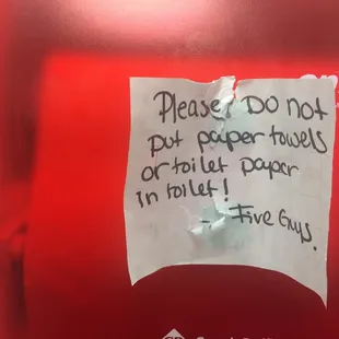 The men's room's homemade signage advises against putting toilet paper in the toilet. This men's room is for number one only.