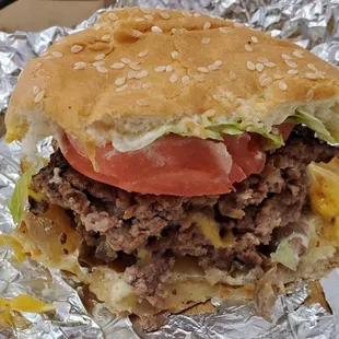 Double cheese burger with lettuce,  tomato,  grilled onions,  lettuce, and mushroom