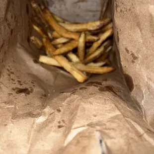 a pile of french fries in a paper bag
