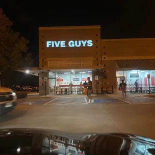 the front of a five guys store at night