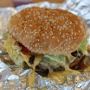 Little cheeseburger with lettuce, tomatoes, grilled mushrooms, and grilled onions