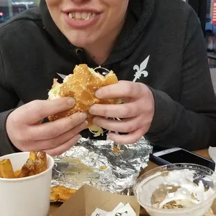 a girl eating a sandwich at a fast food restaurant