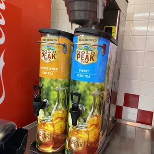 a coffee maker and two cans of iced tea