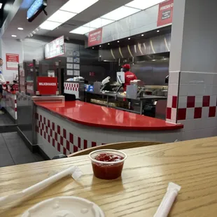 a table with a bowl of ketchup and chopsticks
