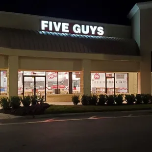 the front of a five guys store at night
