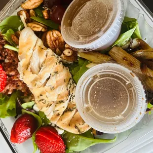 a salad with chicken, lettuce, and strawberries