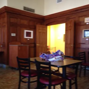 a table and chairs in a wood paneled room