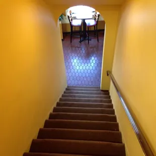 a staircase leading to a table and chairs